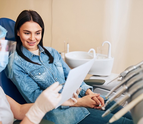 Smiling patient talking with dental team member