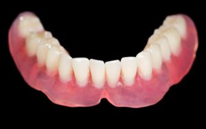 Lower denture featured against dark background